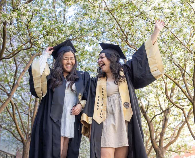 Two CU Denver students walking together in regalia after commencement