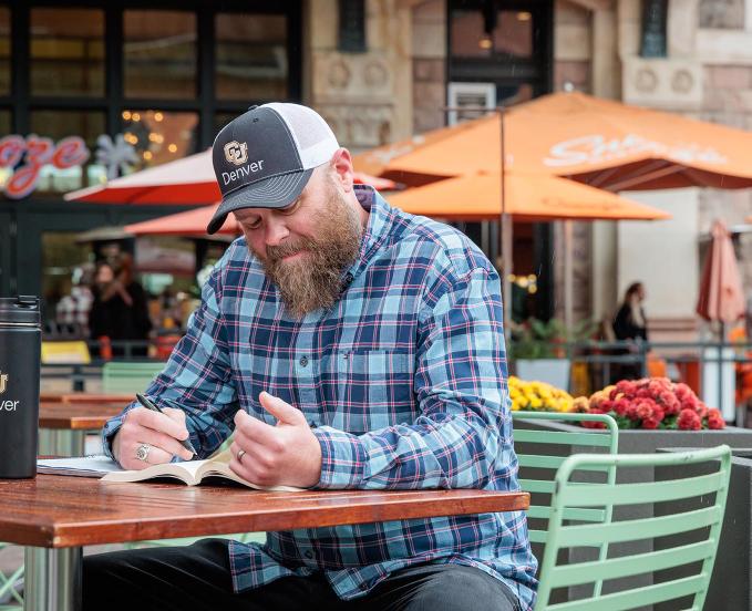 CU Denver student studying for class at table outside of cafe