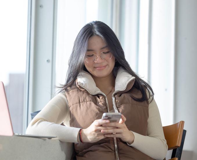 CU Denver student messaging on her phone