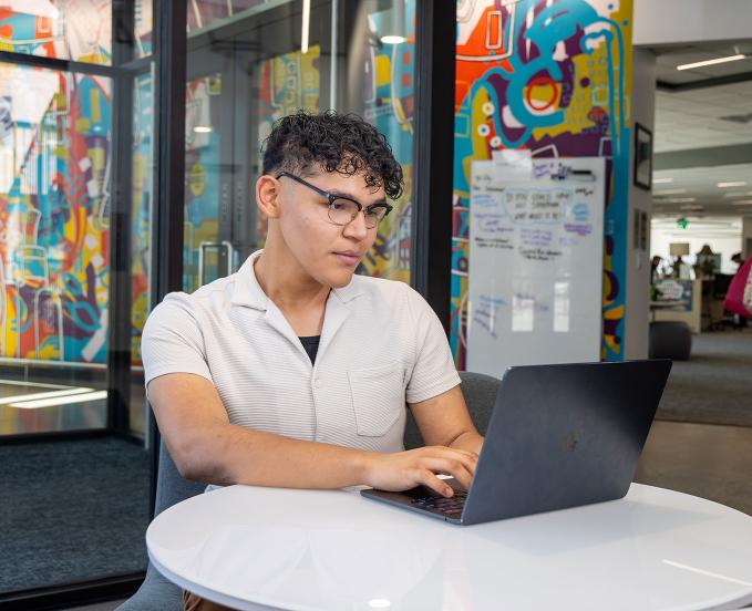 CU Denver student working on laptop on campus