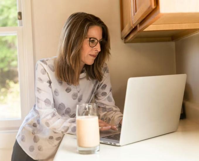 CU Denver online student working on coursework in the kitchen