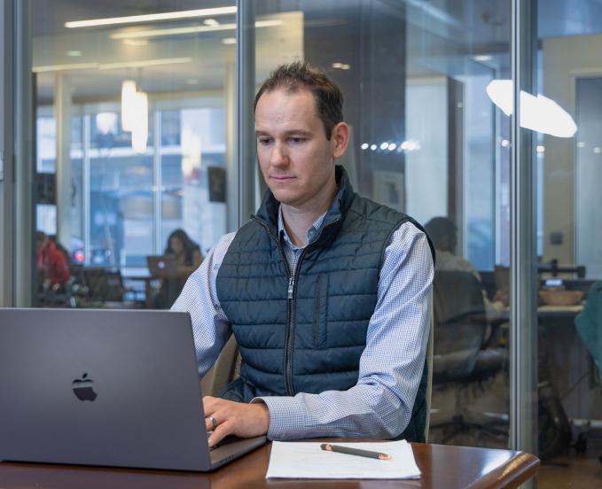 CU Denver student working on laptop in office