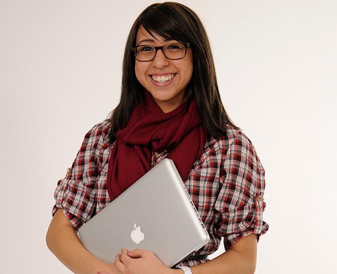 CU Denver HDFR student smiling while holding laptop in arms