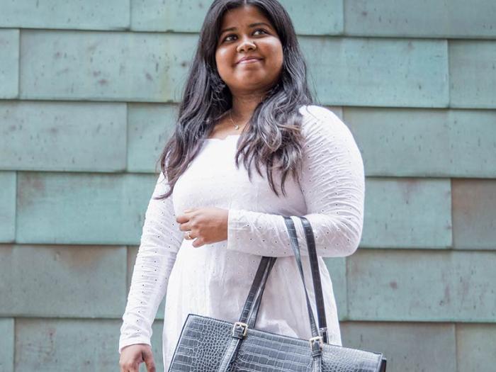 CU Denver student holding bag smiling and looking away from camera