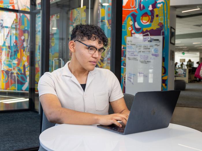 CU Denver online student working on laptop in office