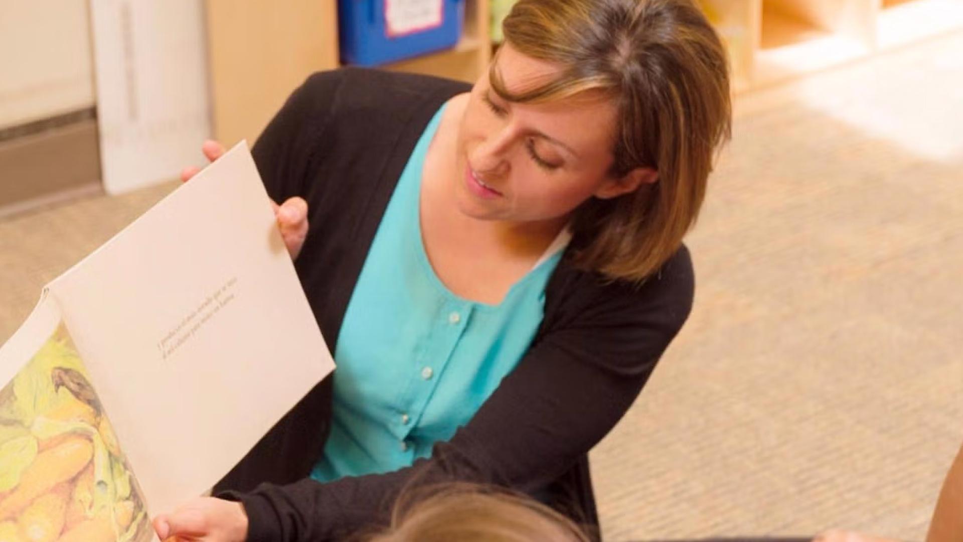 Teacher reading book to elementary aged students