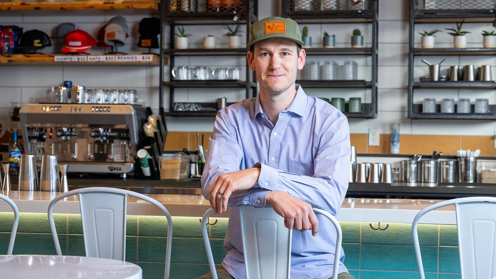 CU Denver MBA student sitting at breakfast bar in his business