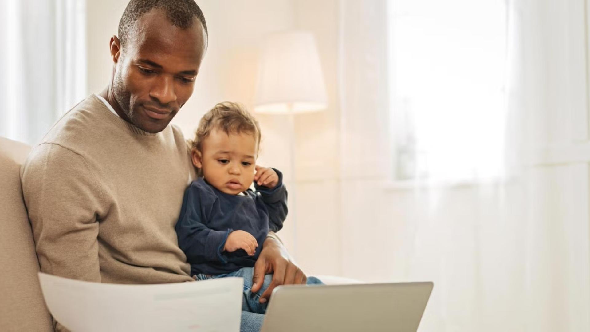 CU Denver student doing classwork with child on lap
