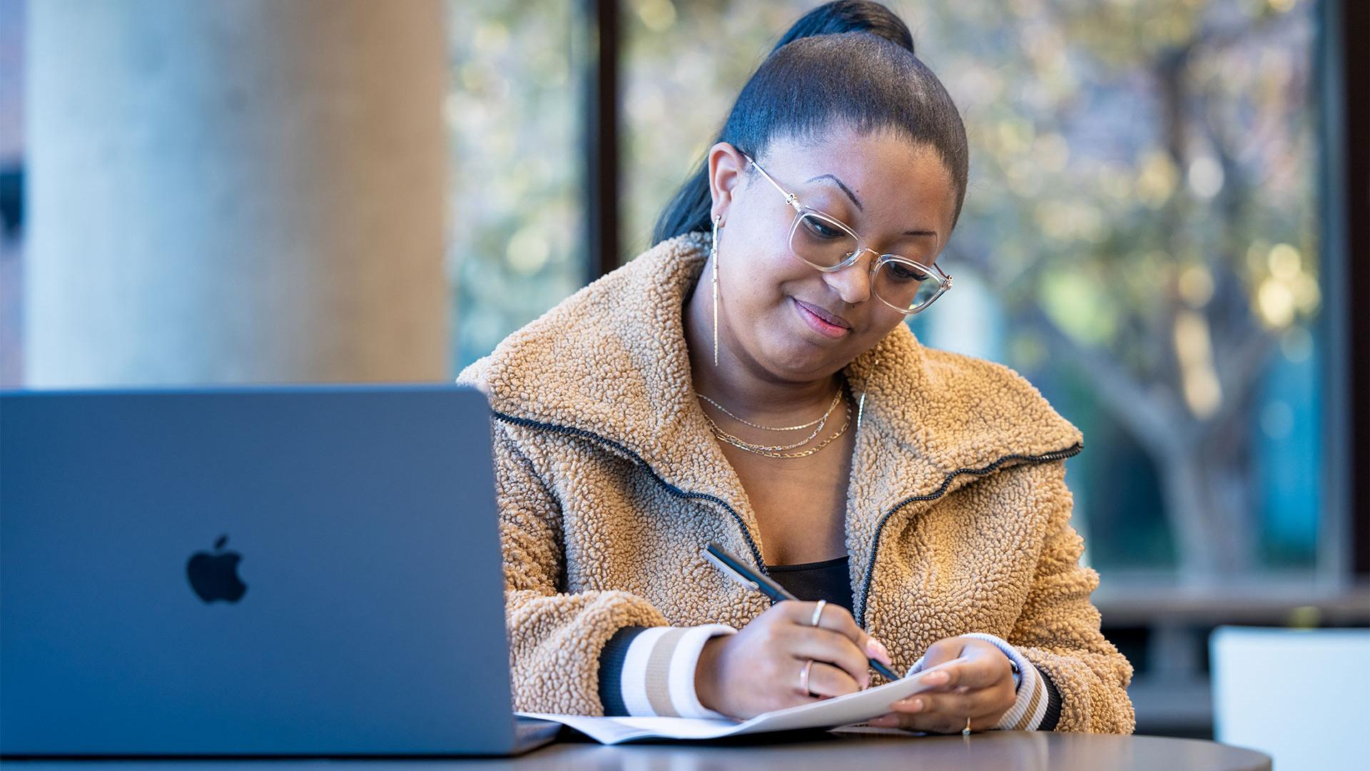 CU Denver online student working in the library