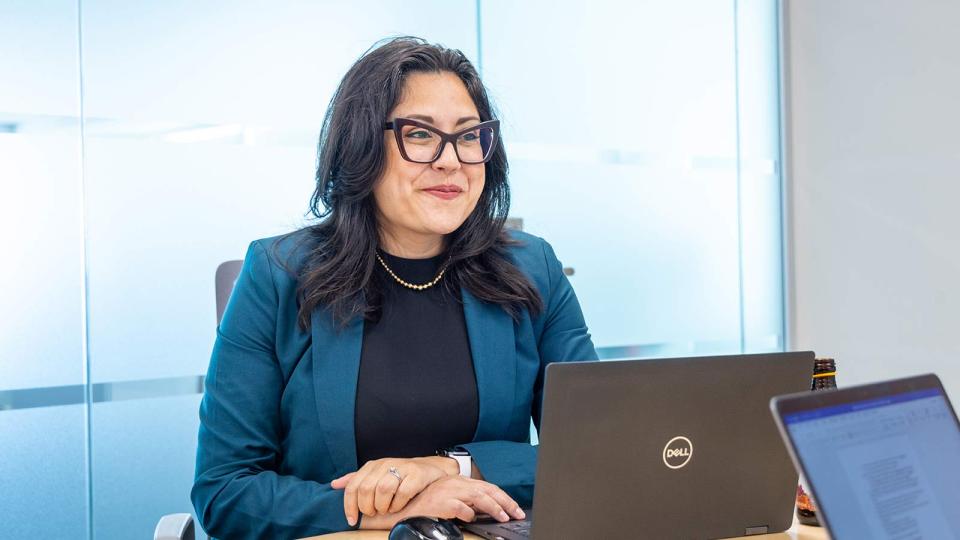 Confident business woman listening in on a meeting with a laptop open.