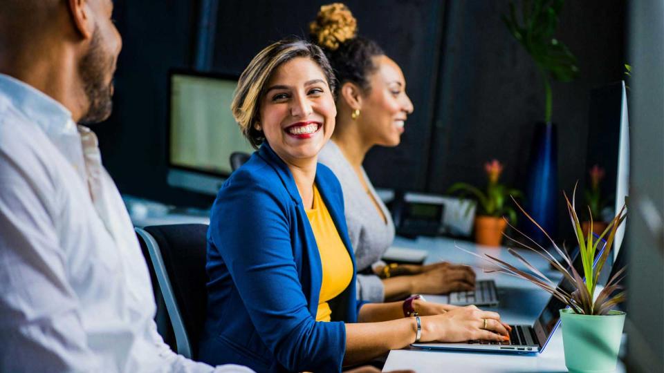 Group of working professionals using laptops and talking